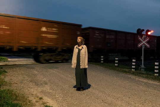 woman stands near a passing train