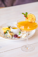 orange cocktail on a white background. decorated with a slice of dry orange