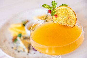 orange cocktail on a white background. decorated with a slice of dry orange