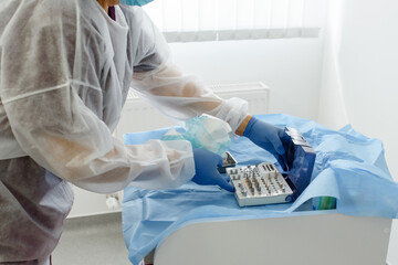  Close up hands of dental surgeon  holding dental implant kit instrument and prepare for dental implant intervention.