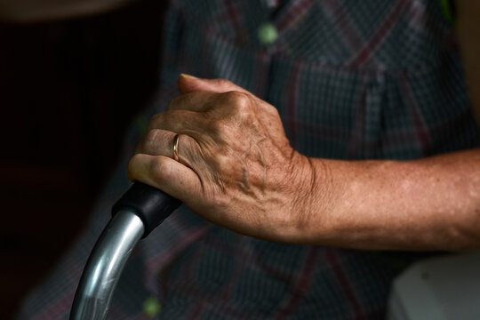 Close-up of an old lady holding her walker