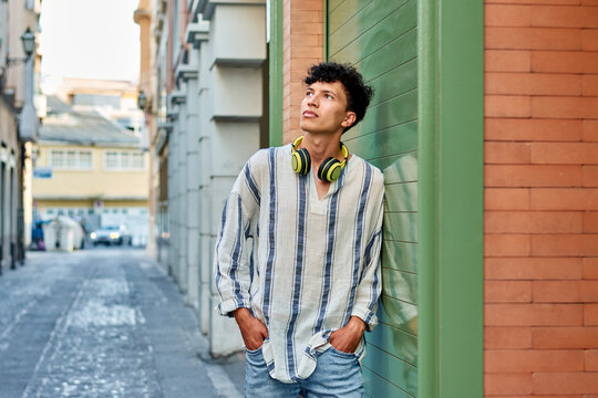 Young afro-haired man with headphones looks up