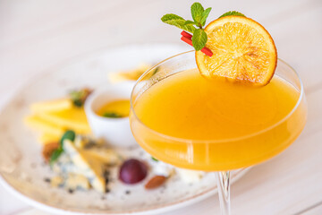orange cocktail on a white background. decorated with a slice of dry orange
