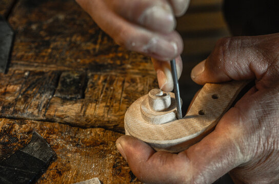 Violin maker luthier hand working a new violin scroll