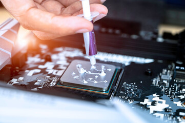 technician squeezing the fresh thermal paste compound on the top of cpu in the socket. the concept of computer hardware, repairing, upgrade and technology.