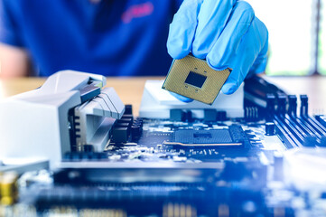 technician is putting the CPU on the socket of the computer motherboard. the concept of computer...