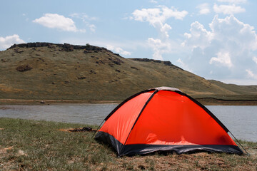 A red tent on the river bank.