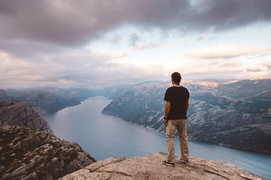 Man standing at edge of cliff at Preikestolen, Norway
