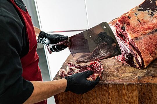 Butcher preparing and cutting mea
