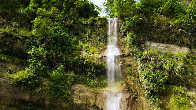 Beautiful waterfall in green forest, top view. Tropical Can-umantad Falls in mountain jungle. Bohol, Philippines. Waterfall in the tropical forest.