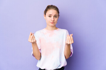 Young caucasian woman on purple background showing that she has no money.