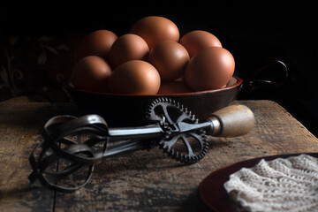 fram house fresh eggs on a wooden table with iron whisk