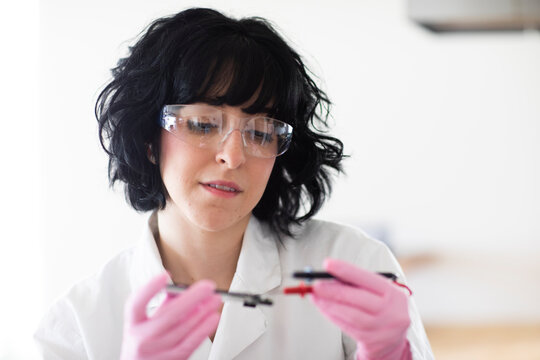 young woman scientist portrait with gloves and safety glass