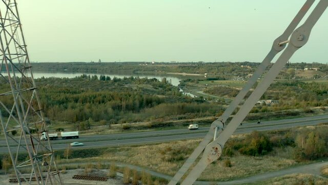 Aerial drone shot of a profitable open cast mining site with an industrial bucket wheel excavator next to a highway with driving cars passing by in Germany
