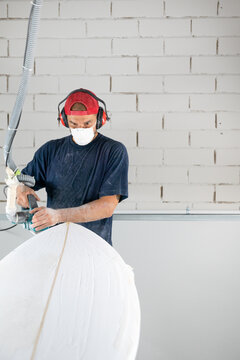 Surfboard Modeling Workshop - Man shaping a surfboard with a sander