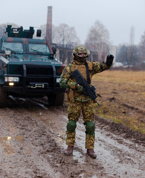 soldier stops the car with a machine gun in his hands