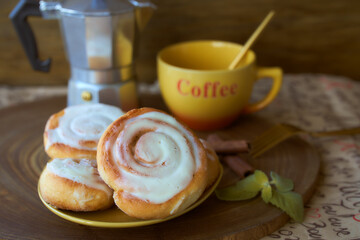 Geyser coffee maker and cinnamon bun on a wooden tray. With coffee cup and spoon. Dark background