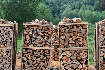 Stacks of chopped firewood loaded on pallets and ready for sale on sawmill