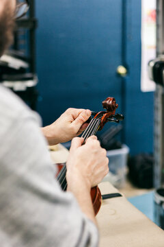 Band: Man Replacing Strings On Violin