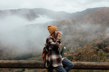 Portrait of woman traveling and exploring nature, preparing tea in a high place.
