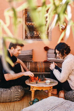 Happy Caucasian Couple Playing Chess on Vacation