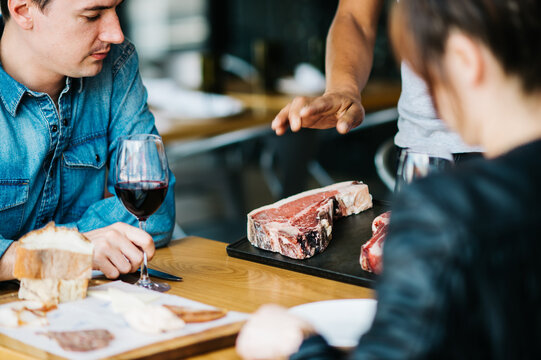 Dining patrons learning about the days meat cuts - Powered by Adobe