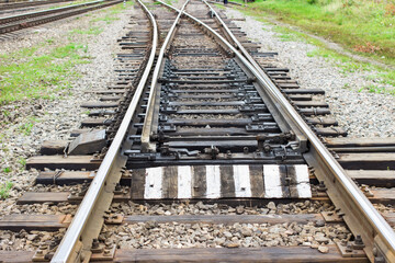 Fototapeta na wymiar Rail tracks with rail sleepers at the railway pointwork. Change of direction. Railway arrows with rail track elements.