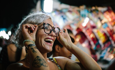 Young woman having fun trying on glasses