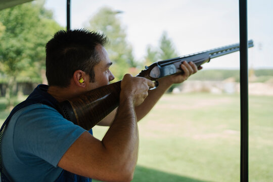 Mid Adult Man Training His Aim and Concentration Using a Shotgun in a Clay Pigeon Shooting Field Sport Centre