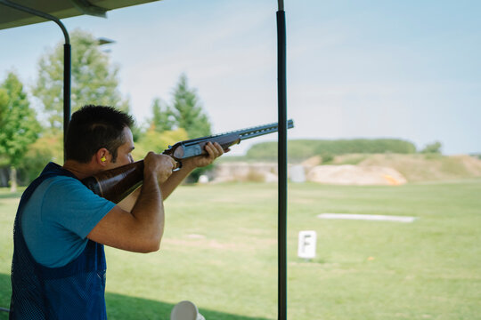 Mid Adult Man Training His Aim and Concentration Using a Shotgun in a Clay Pigeon Shooting Field Sport Centre
