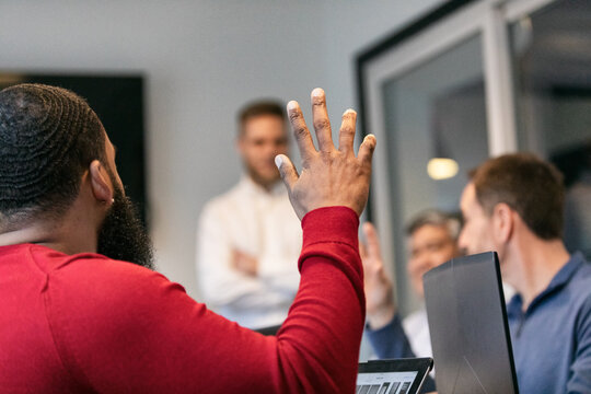 Business: Man In Meeting With Hand Raised