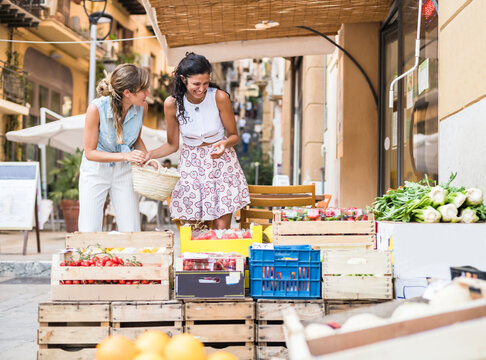 Best friends on vacation at fruit market - Powered by Adobe
