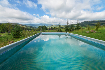 Wide angle shot of the open air pool with a mountain view.