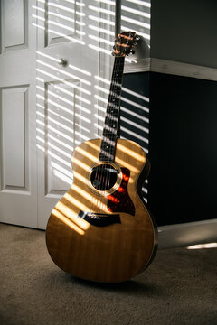 Acoustic Guitar against a wall