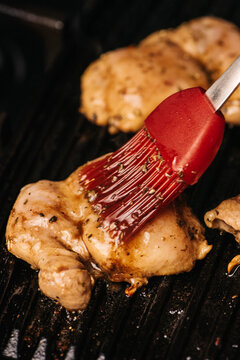 Basting chicken breasts on the grill