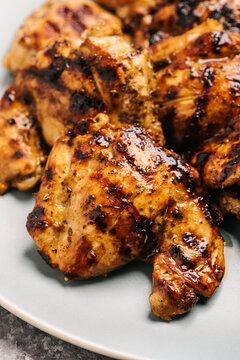 Whole cooked marinated chicken breasts on a plate.