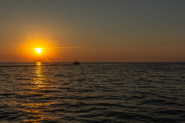 Fototapeta na wymiar boat rushes through the sea during sunset. city of Sochi.