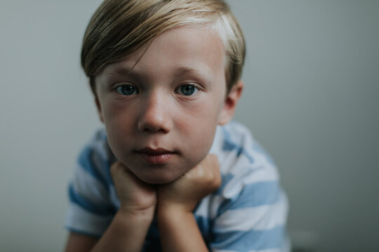 Pensive little blond boy looking at the camera