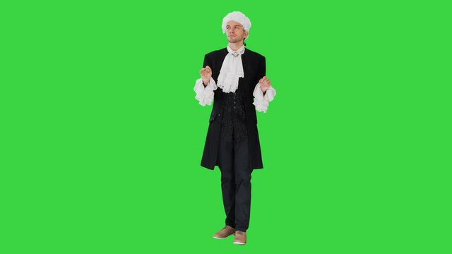 Man dressed in courtier frock coat and white wig thinking and fidgeting with his fingers on a Green Screen, Chroma Key.
