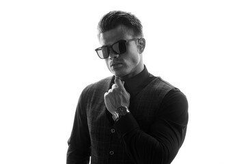 Black and white portrait of beautyful guy on white background. High fashion model posing in studio. Attractive man in classic suit and sunglasses.