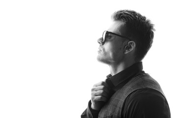 Black and white portrait of beautyful guy on white background. High fashion model posing in studio. Attractive man in classic suit and sunglasses.