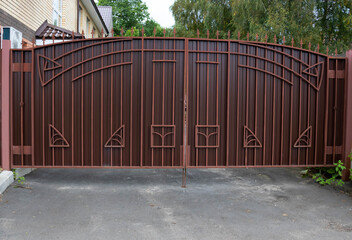 New forged metal double gates for entry of cars into the yard closed