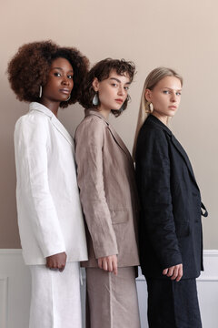 A small group of fashion multiracial multiethnic young beautiful sensual models are sitting in luxury room on sofa