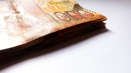 1000 Kenya bank notes in a bundle and on white. Close up. One thousand, cash money. Currency of...