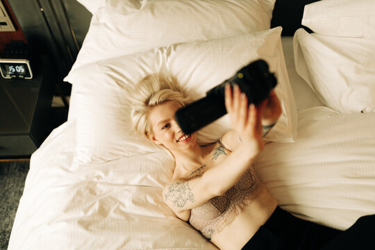 happy woman with small camcorder on the bed