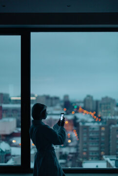 young woman near the window with cell phone
