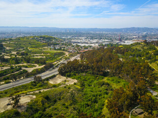 gorgeous aerial shot of lush green trees, grass and plants, hills in the city of Los Angeles around...
