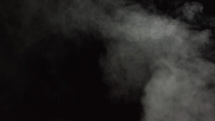 Soft Fog in Slow Motion on Dark Backdrop. Realistic Atmospheric Gray Smoke on Black Background....