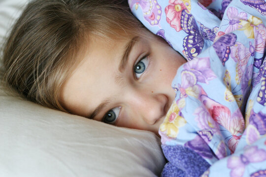Young Blue Eyed Girl Snuggled Up with her Blanket