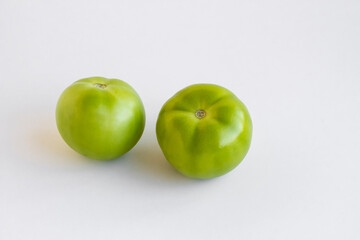 Ripe,green tomatoes for pickling on white with copy space.